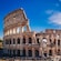 The Roman Colosseum with ancient stone arches under clouds in the sky